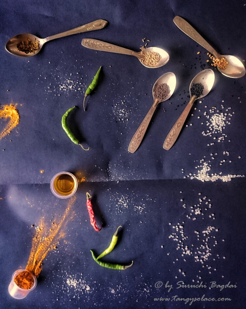spoonfuls and sprinkles of masalas and spices on blue background
