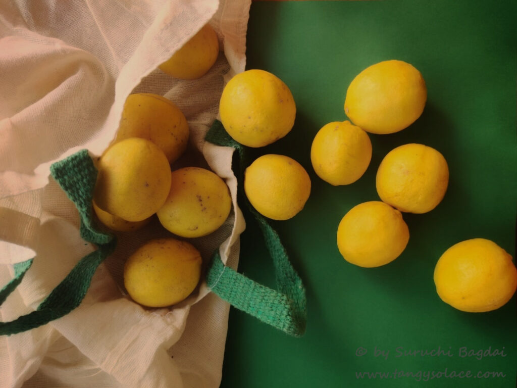 Lemons in a white bag over green background