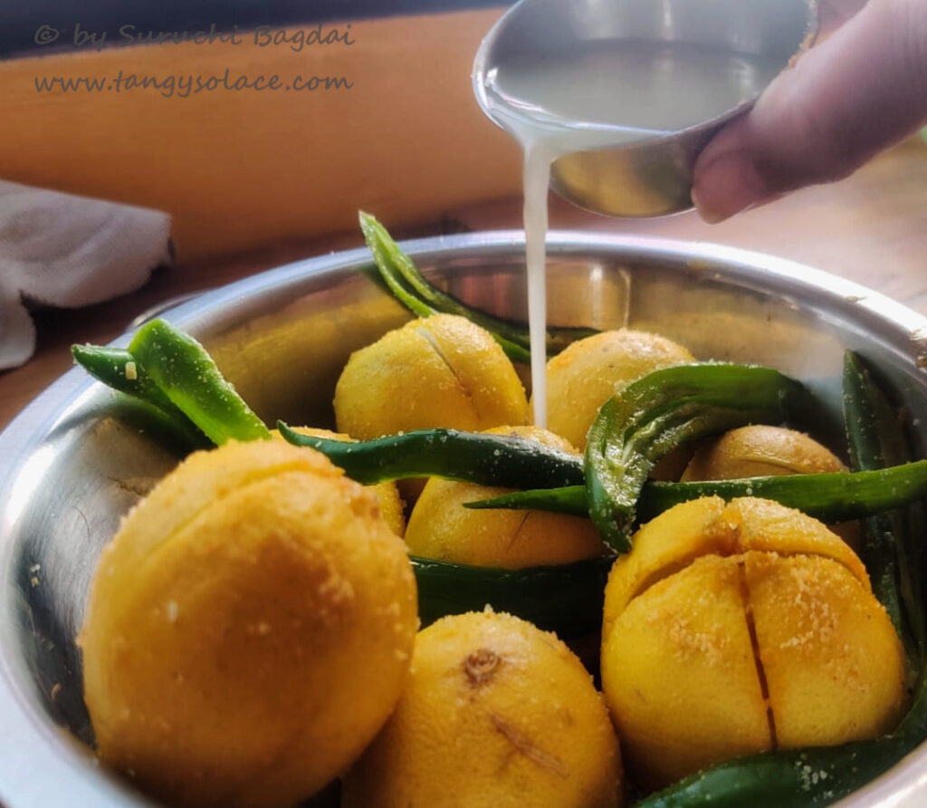 Adding lemon juice to salted lemon quarters and slit chillies