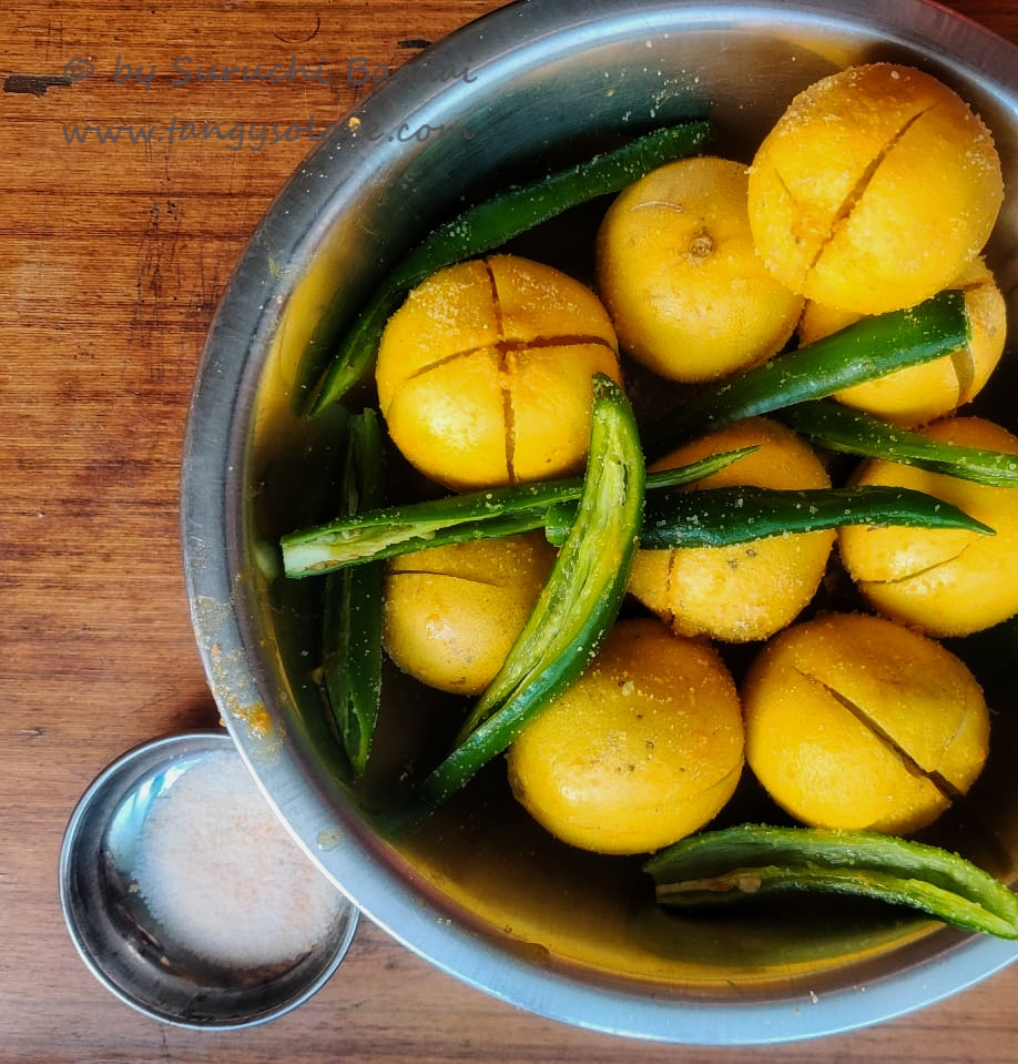 salted lemon and slit chillies in a steel mixing bowl