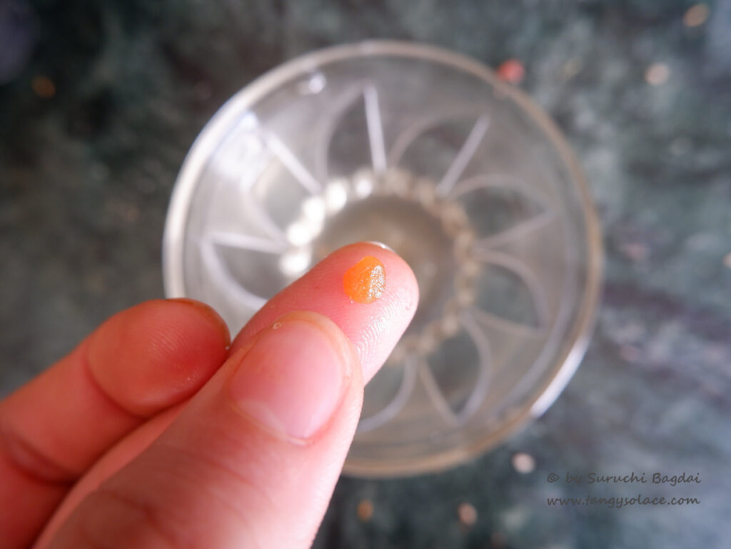 checking the jaggery syrup consistency over a bowl of water