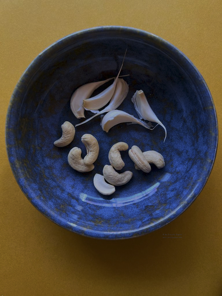 cashew and garlic cloves in blue bowl