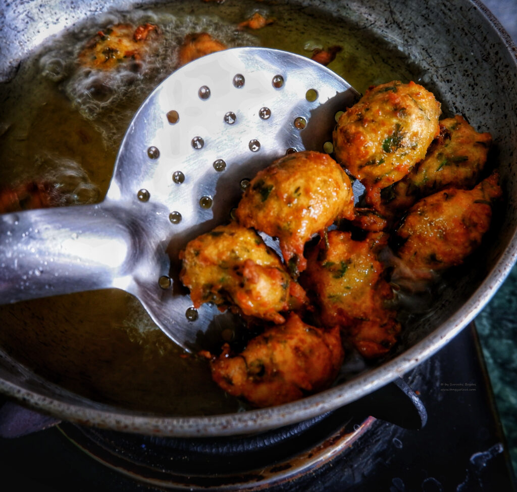 Draining fried makai na bhajiya 