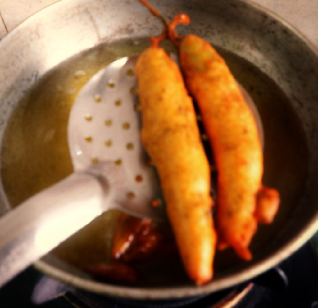 Draining fried marcha na bhajiya 