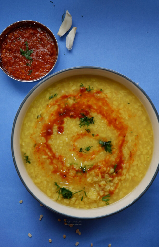 urad dal with chutney swirl on top on blue backdrop