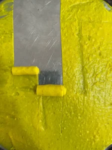 Spread khandvi batter being rolled