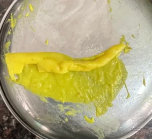 khandvi roll peeling cleanly against steel thali